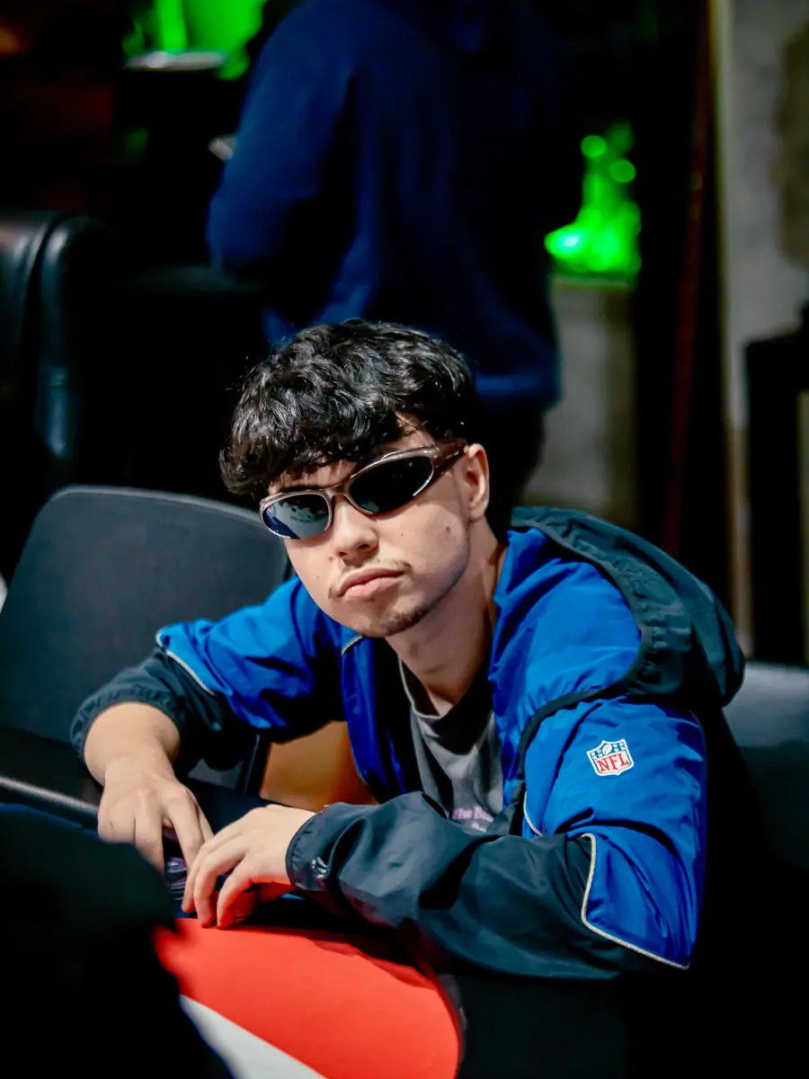 Jogador de óculos escuros e jaqueta azul na mesa