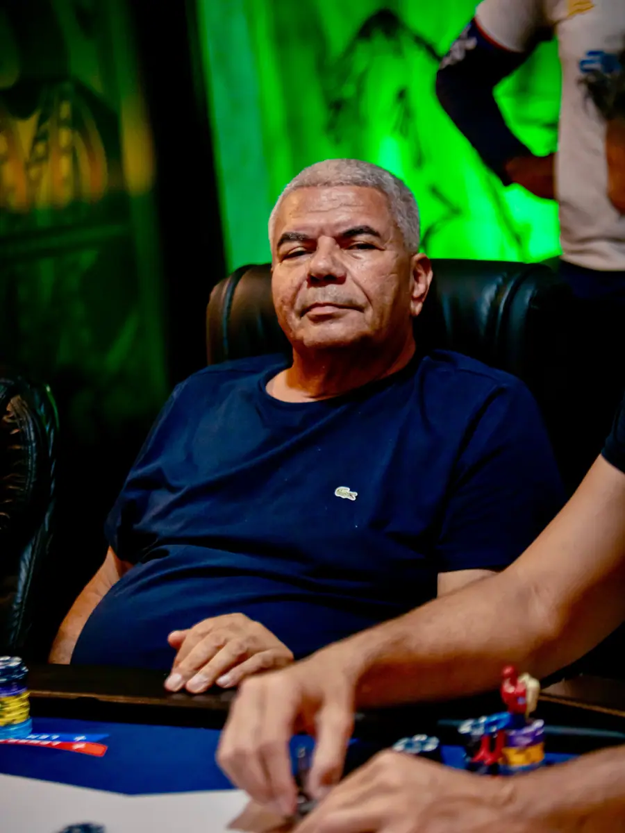 Jogador grisalho de camiseta azul-marinho sentado à mesa